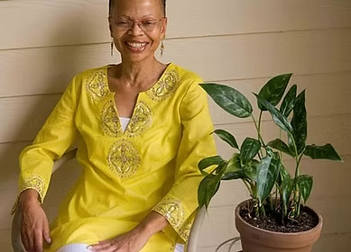 Patricia A. Crisp smiling beside a plant